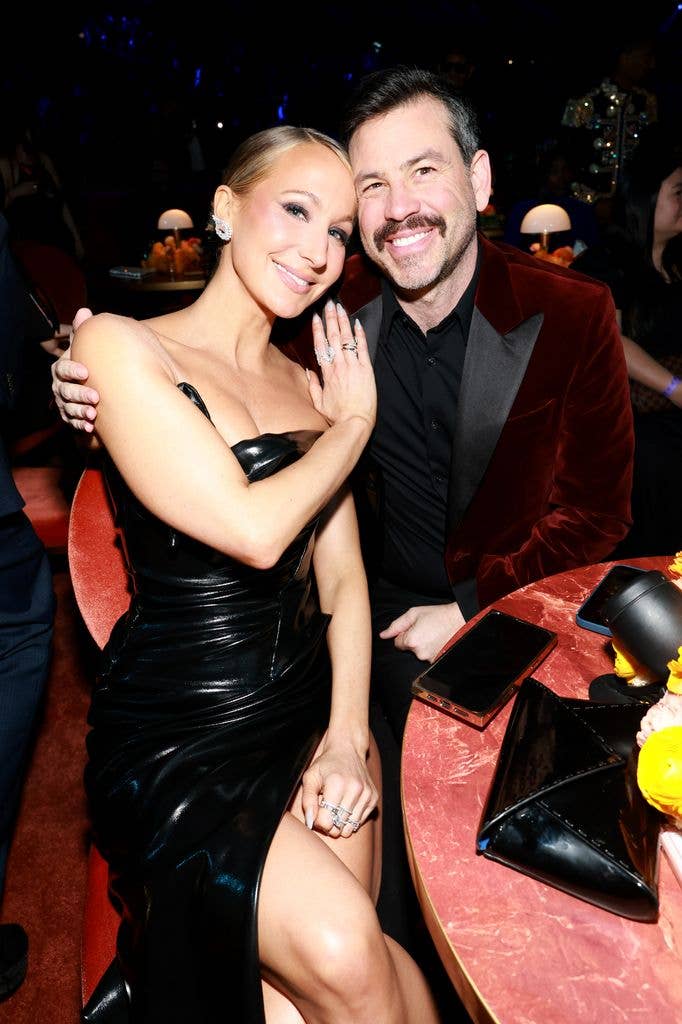 Nikki Glaser in black dress and Chris Convy in red blazer in February 2026