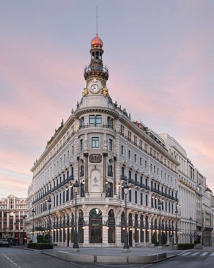 The outside of Four Seasons Madrid with a sunset backdrop 