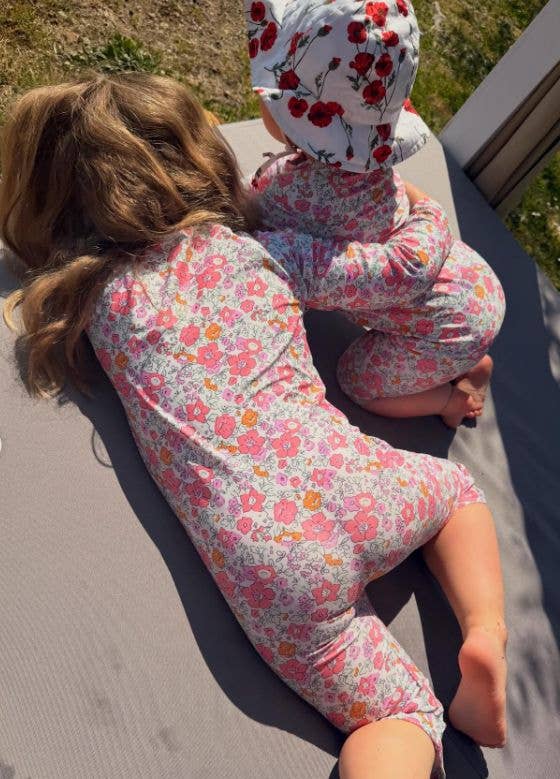 Two young girls in floral swimsuits