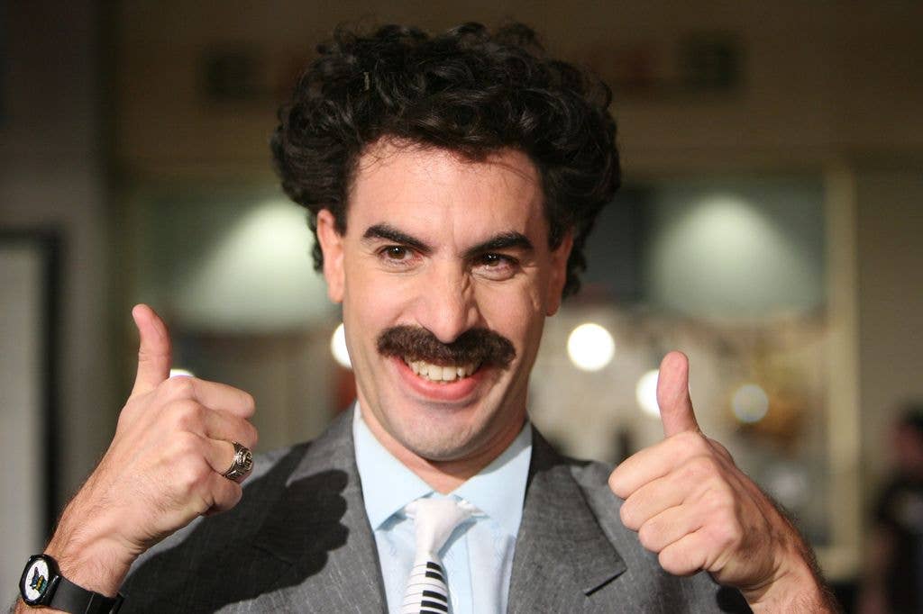 Sacha Baron Cohen as Borat holding two thumbs up, in a grey suit, blue shirt and piano tie, during "Borat: Cultural Learnings of America For Make Benefit Glorious Nation of Kazakhstan" Premiere 