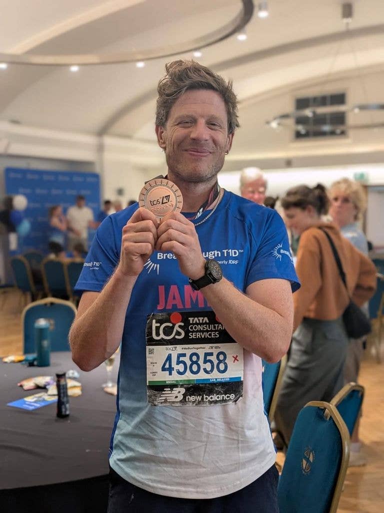 A photo of James Norton holding his medal