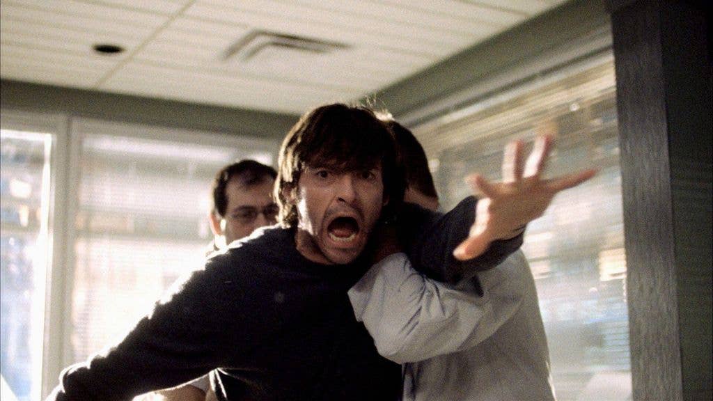 Hugh Jackman being dragged away by two doctors in a still from The Fountain