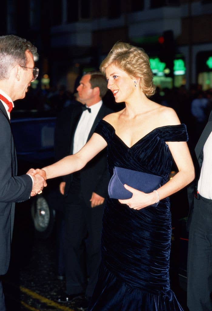 Princess Diana shaking hands in a shoulderless dress