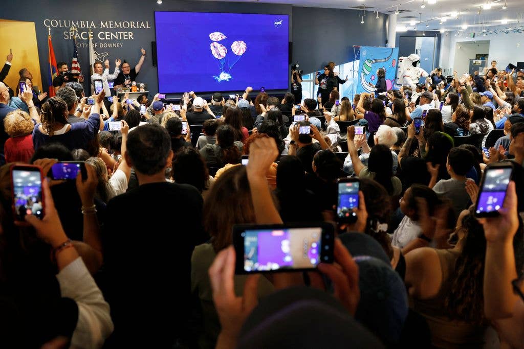 People celebrate as the Artemis II mission concludes with a successful splashdown