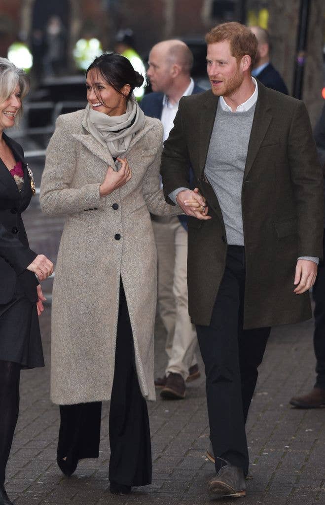 Meghan Markle in a grey jacket with Prince Harry in a green jacket