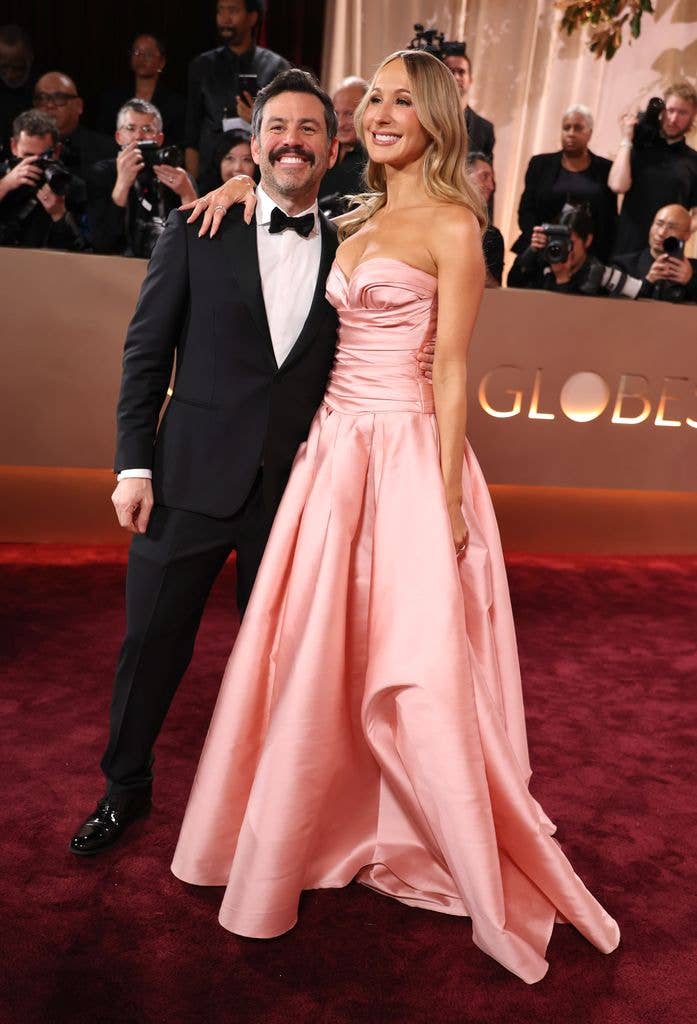 Chris Convy in tuxedo and Nikki Glaser in pink dress attend the 83rd annual Golden Globe Awards 