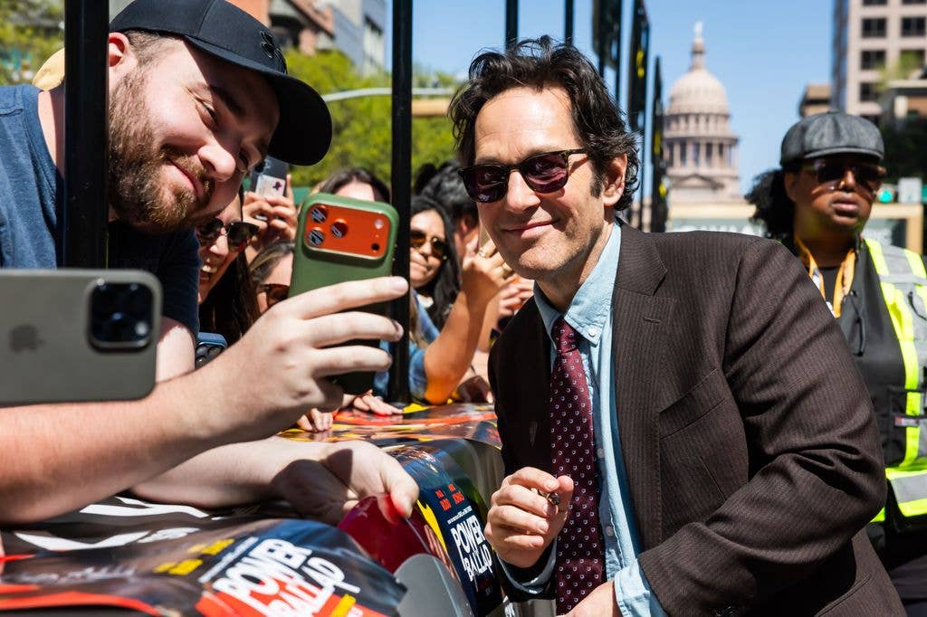 Paul signs autographs and poses for photos with fans