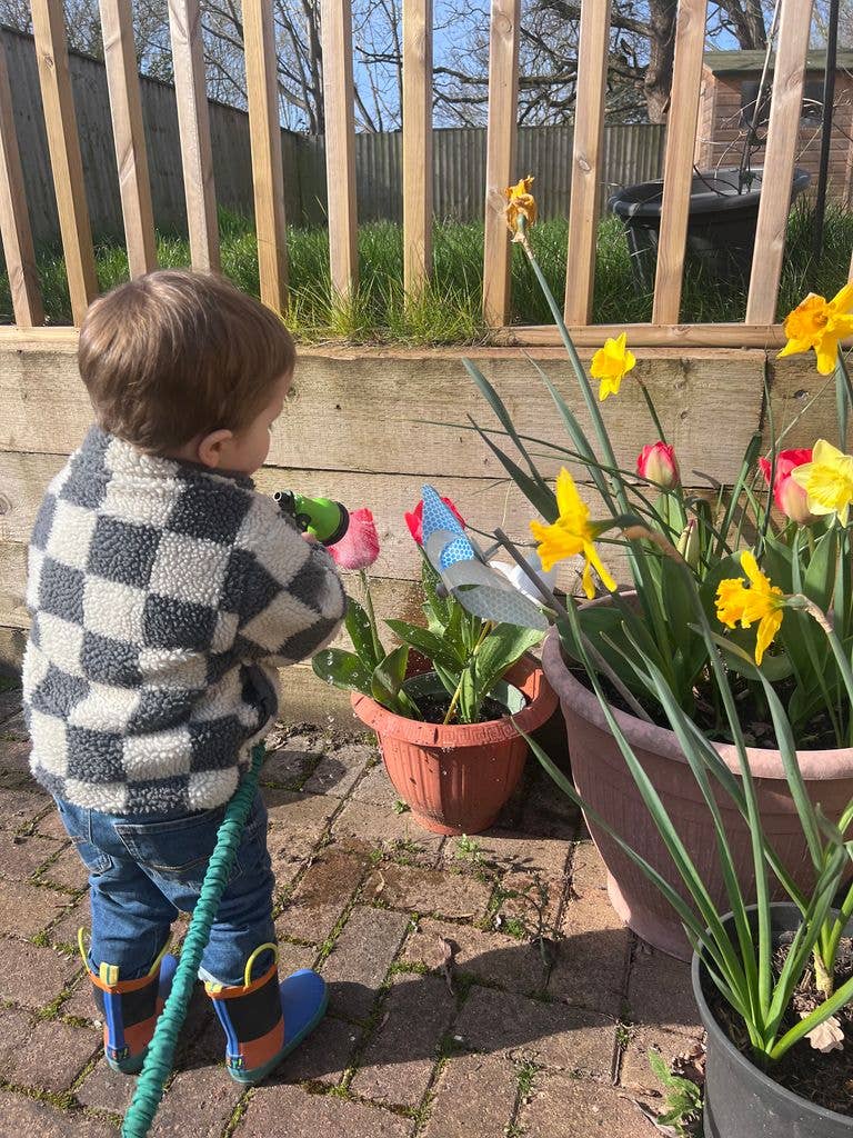 young boy watering flowers