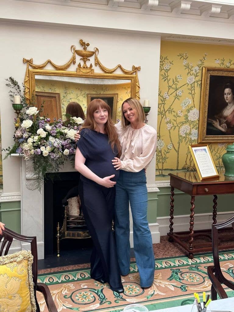 A photo of a blonde lady with a bob holding a red hari lady's bump