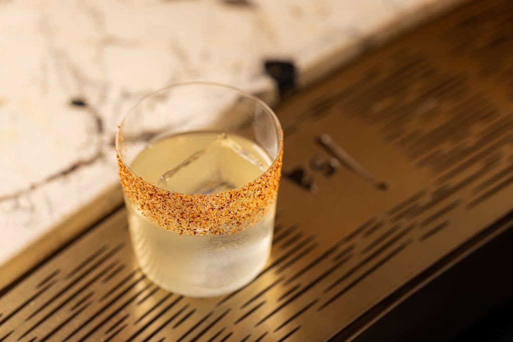 A cocktail with an decorated orange rim 