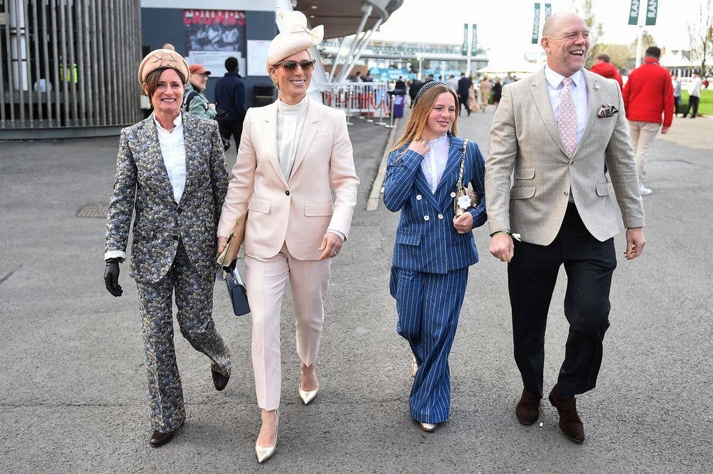 Zara Tindall, Mike Tindall and their daughter Mia walking in a line in suits