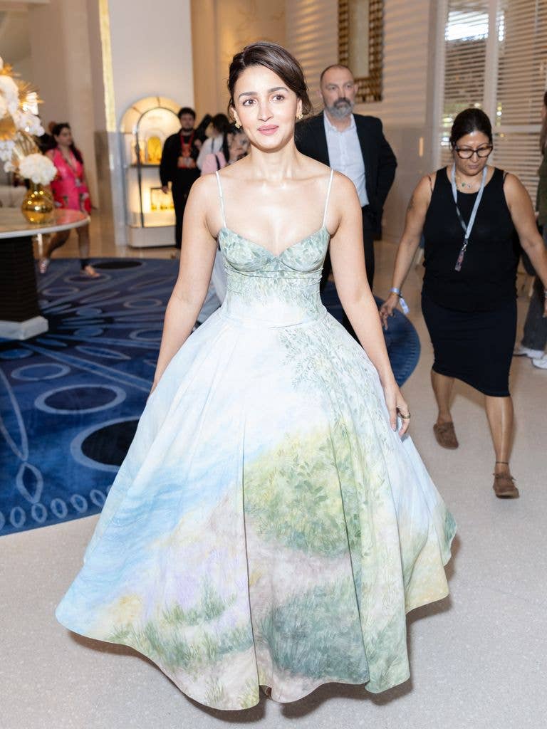 Alia Bhatt wears a strappy dress with full skirt with a pale pastel landscape printed onto it