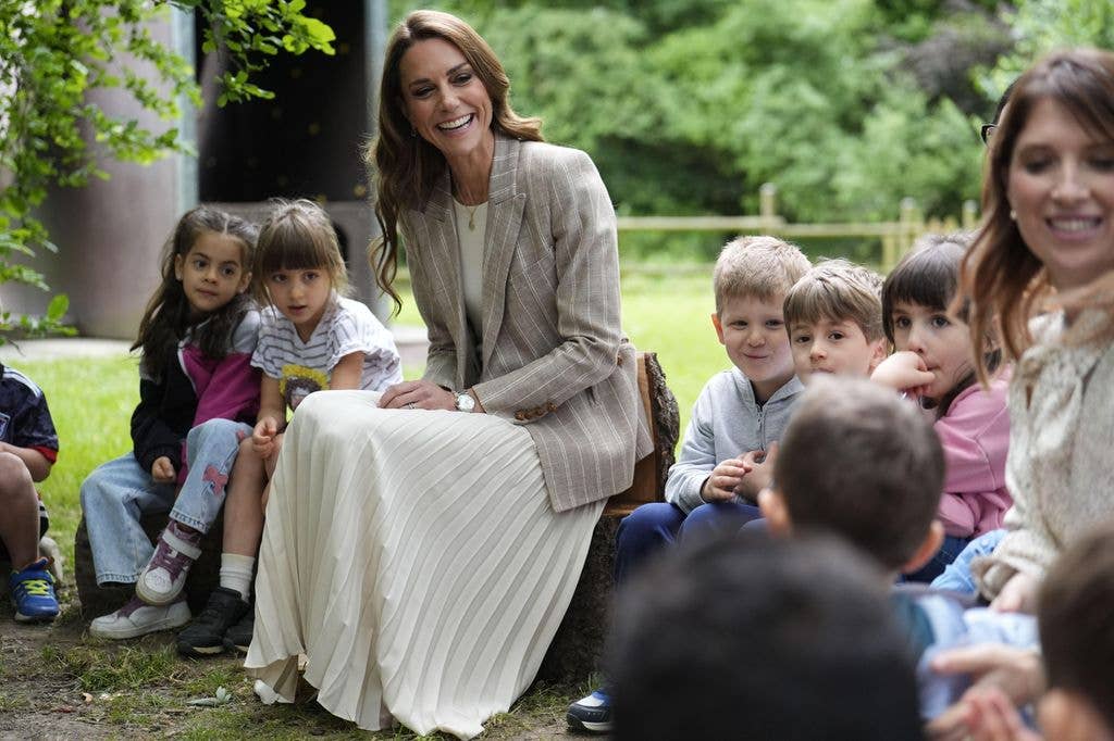 Kate Middleton sitting with a group of children in a forest