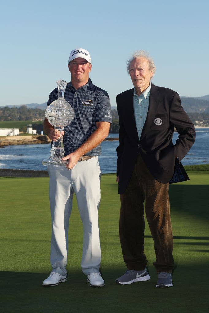 Tom Hoge of the United States celebrates with the trophy and actor Clint Eastwood after winning during the final round of the AT&T Pebble Beach Pro-Am at Pebble Beach Golf Links on February 06, 2022 in Pebble Beach, California