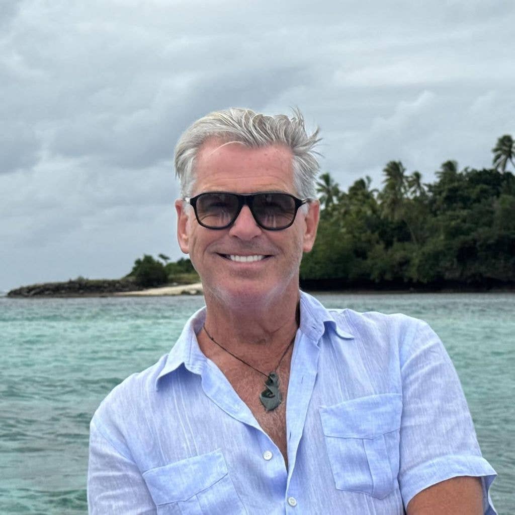 Pierce Brosnan in blue shirt at beach