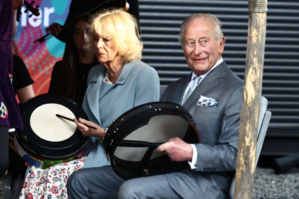 Britain's King Charles III and Britain's Queen Camilla play bodhran drums, traditional Irish drums, as they watch dancers perform to mark Fleadh Cheoil na hÃireann coming to Belfast this August, at Thompson Dock in Belfast, Northern Ireland on May 19, 2026, during their three-day visit to Northern Ireland