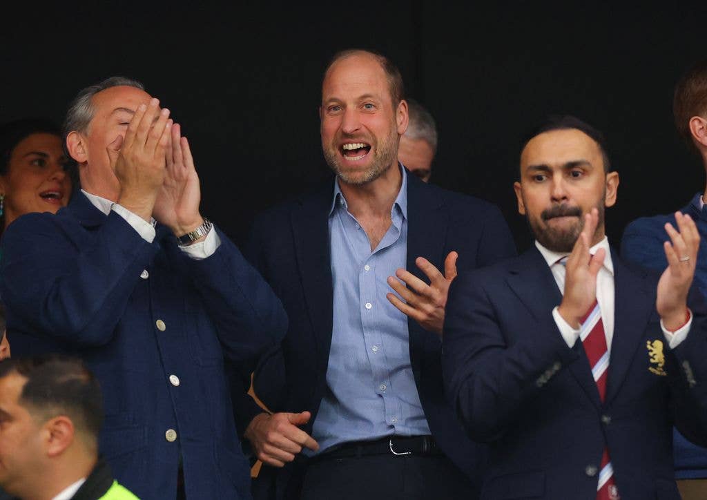 Prince William smiling as men applaud around him