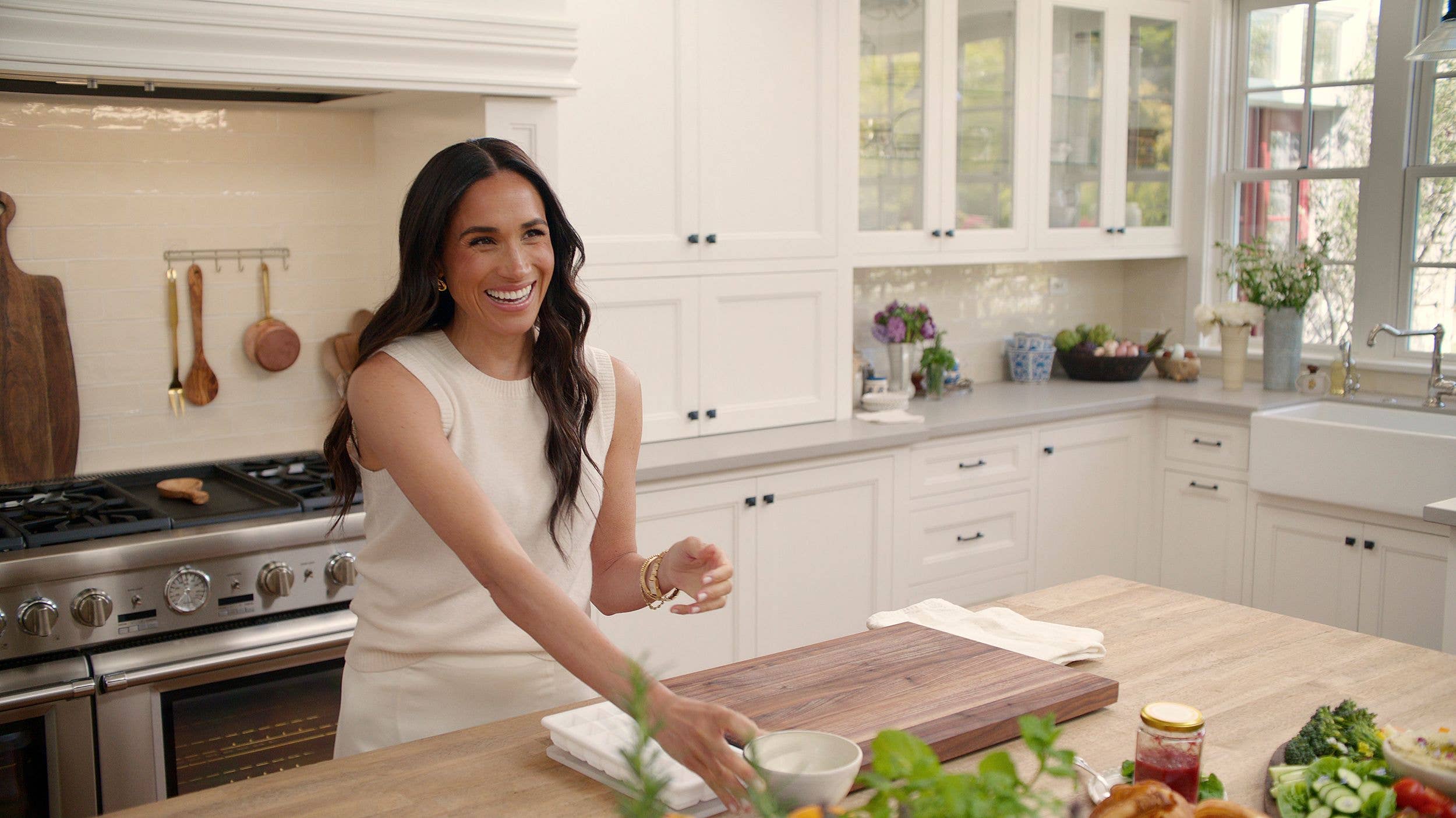 Meghan smiling in a kitchen with utensils in the background