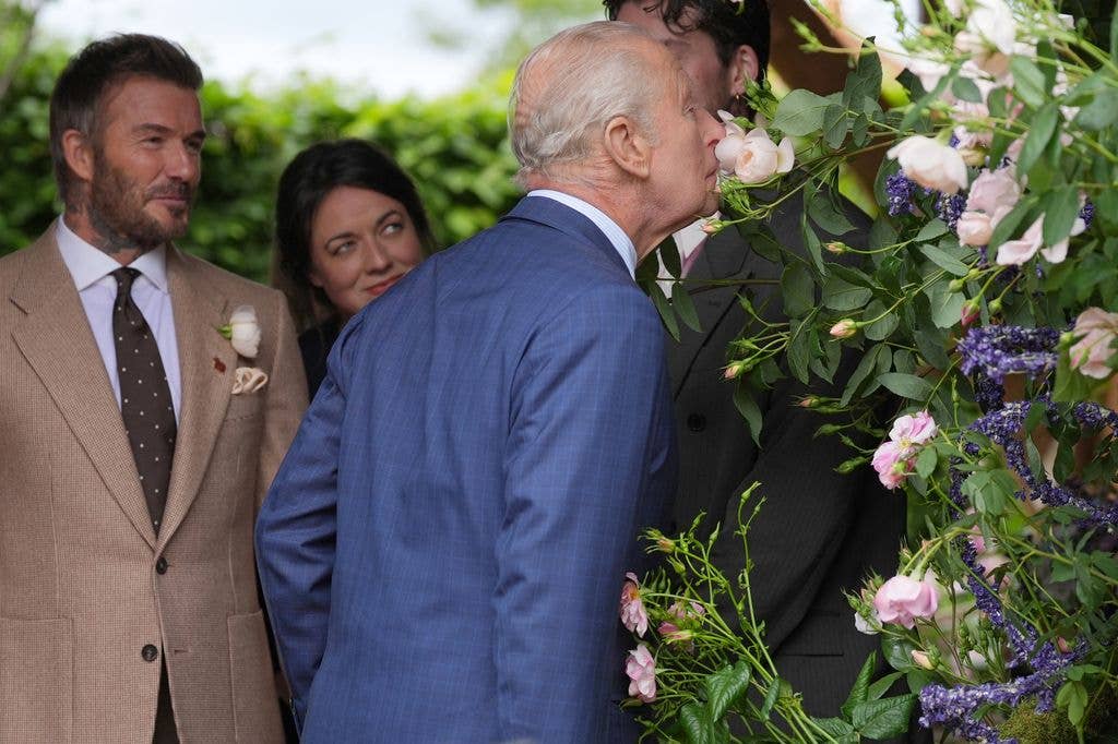 Former England footballer David Beckham (L) and designer Frances Tophill react as Britain's King Charles III smells a Sir David Beckham Rose, by David Austin Roses, at the 2026 RHS Chelsea Flower Show in London on May 18, 2026