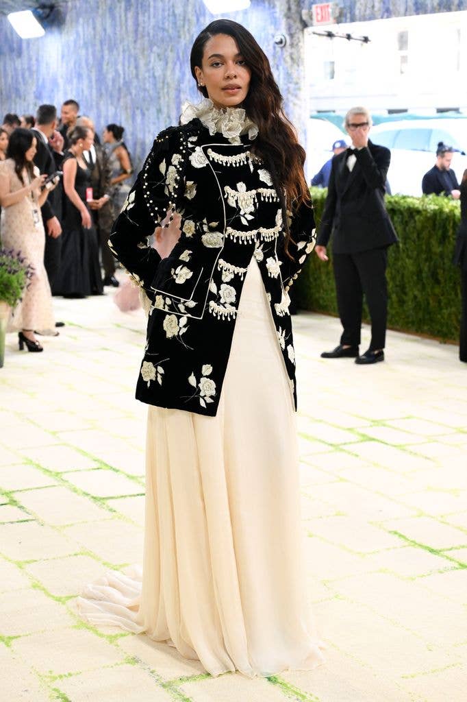 Aurora James wears a back and white embroidered jacket with long cream skirt