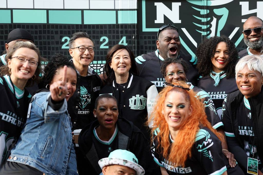New York Liberty Owners Joe Tsai and Clara Wu Tsai pose with dance group Timeless Torches during the New York Liberty Ticker Tape Victory Parade & Rally on October 24, 2024 in New York City