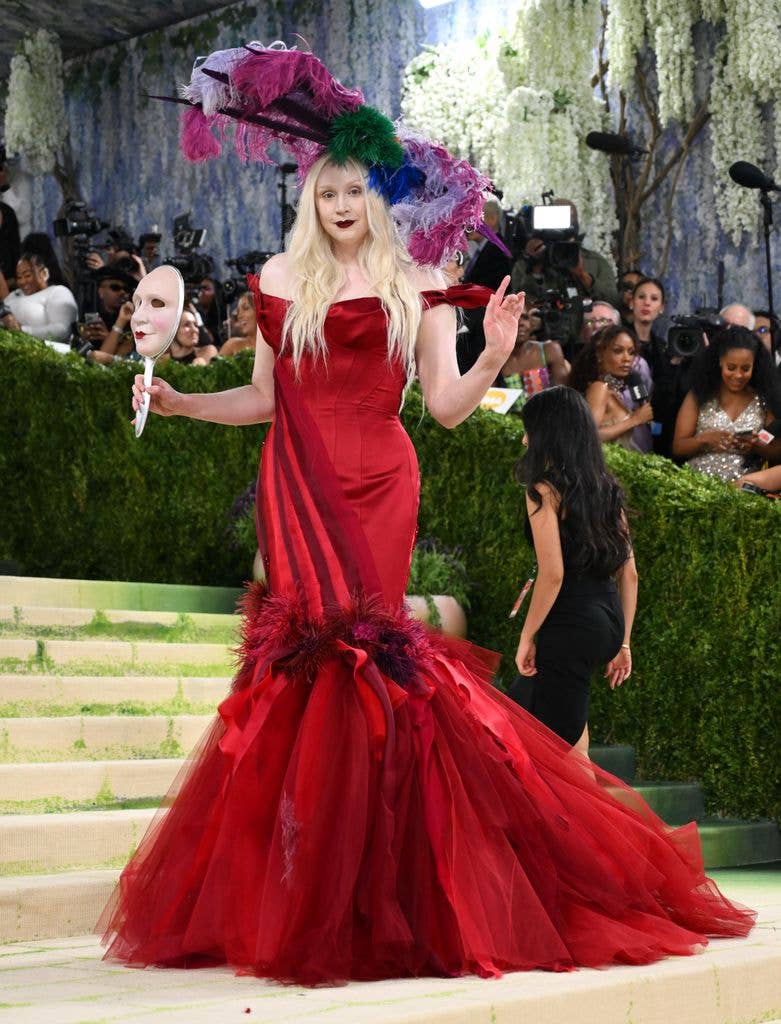 Gwendoline Christie wore a red strapless dress with large feathered hat