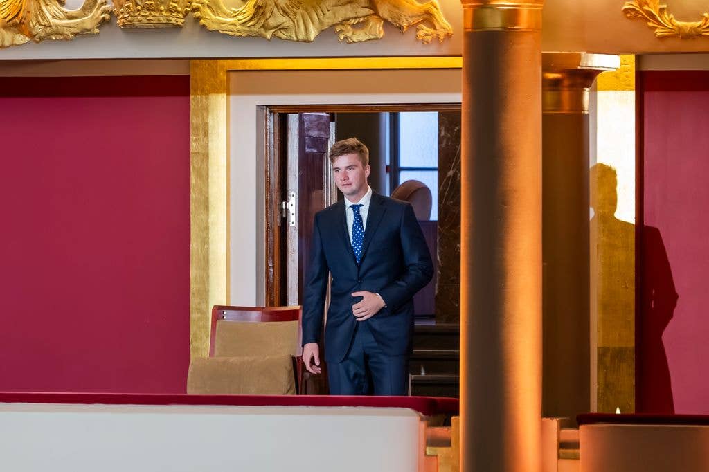 Prince Gabriel in a blue suit heading to a chair
