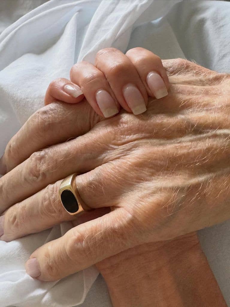 Kaitlin Olson holds her father Donald Lee Olson's hand before his passing, shared on Instagram