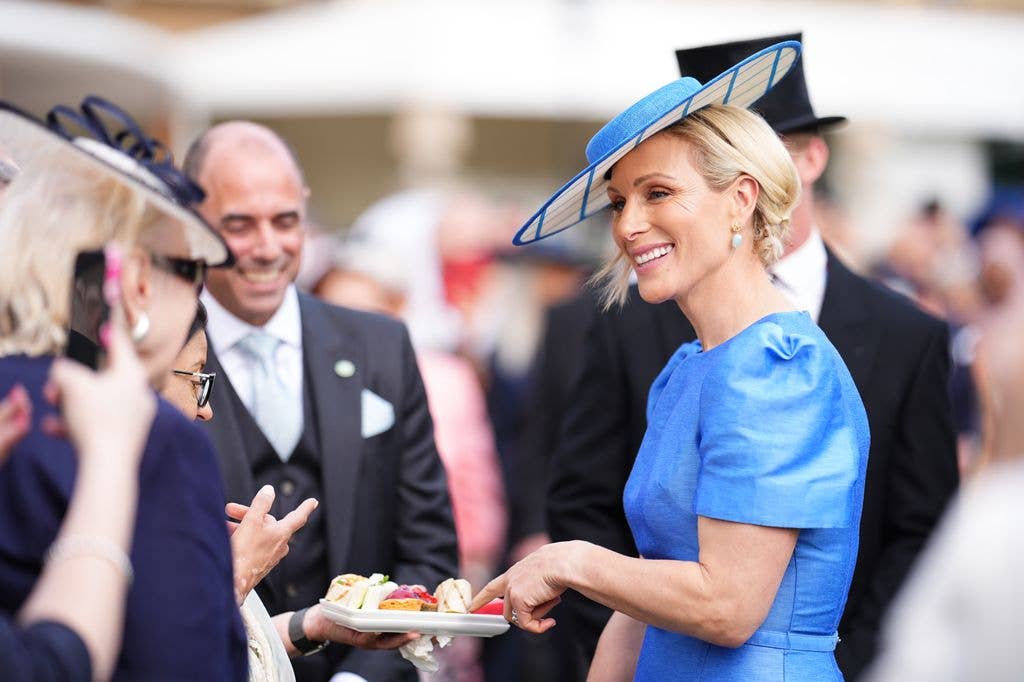 Zara Tindall meets guests during a Royal Garden Party at Buckingham Palace in blue outfit