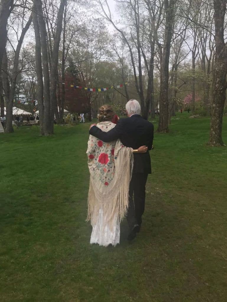 Richard Gere walking hand-in-hand in a park with wife in a white lace dress with a floral shawl