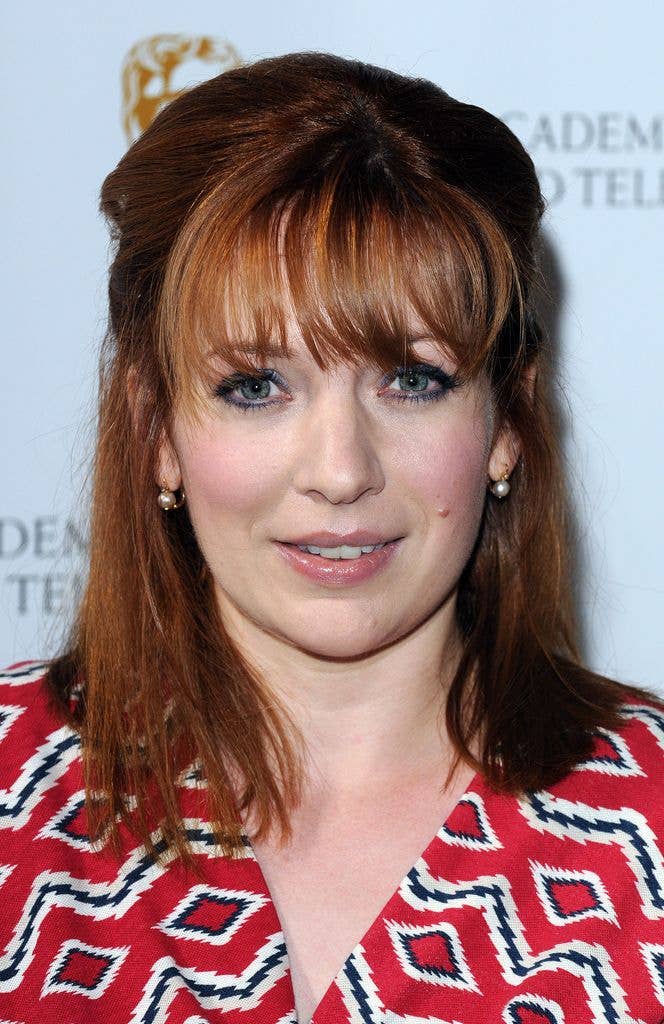 Katherine Parkinson in a red dress with a geometric black and white pattern.