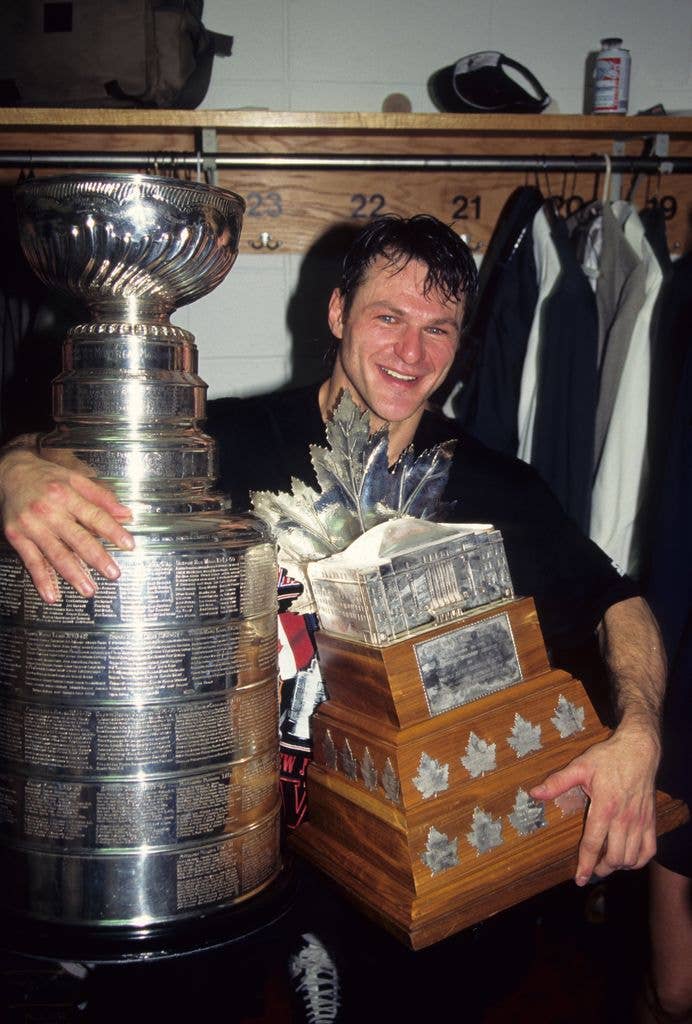 Claude Lemieux #22 of the New Jersey Devils celebrates with the Stanley Cup and the Conn Smythe Trophy after winning 1995 Stanley Cup playoffs against the Detroit Red Wings at Meadowlands Sports Complex on June 24, 1995 in East Rutherford, New Jersey.