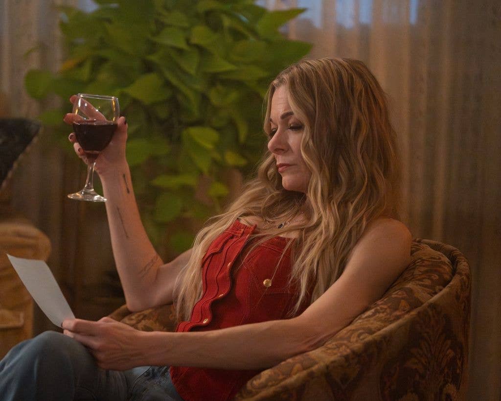 photo of leann rimes holding a glass of wine in 911 nashville