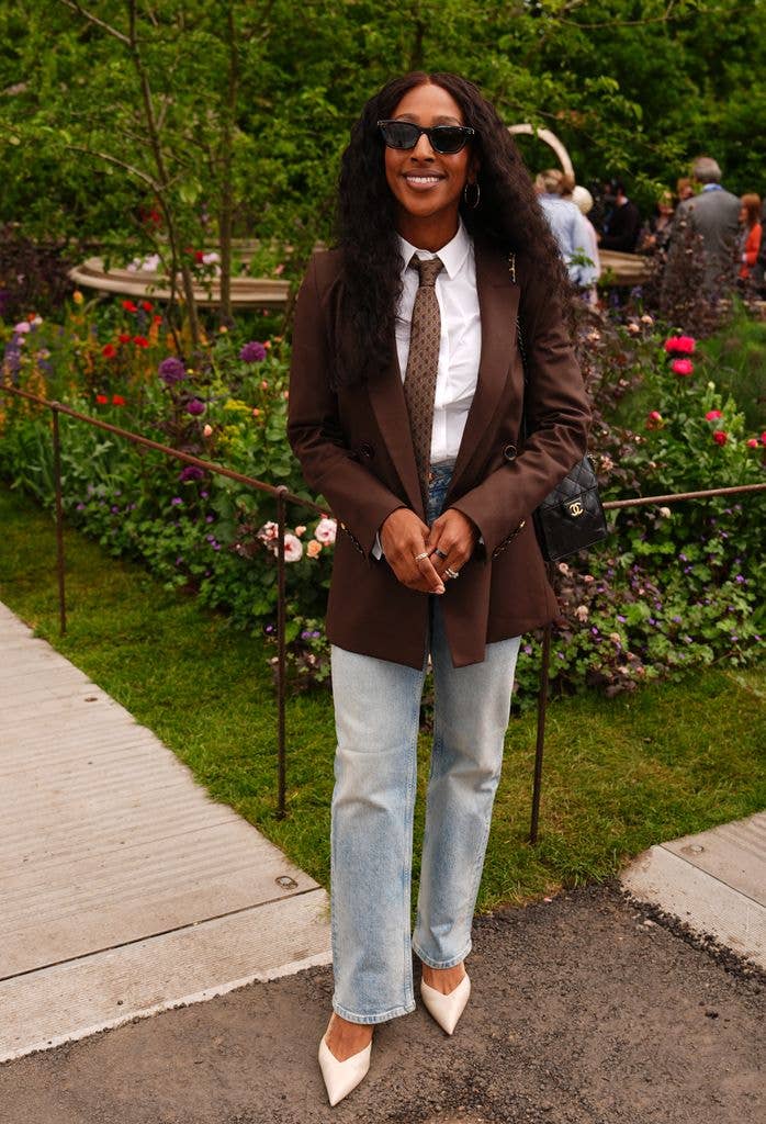 Alexandra Burke wears jeans and a brown blazer, white shirt and tie