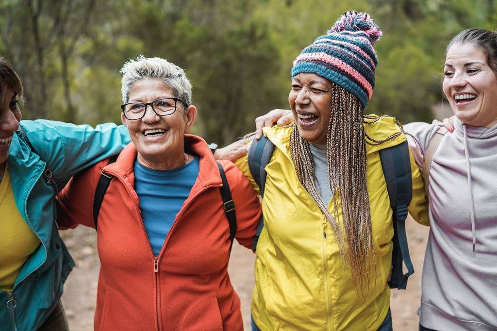 smiling older women walking in a group outdoors with support network