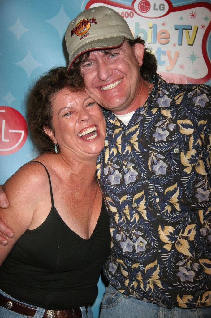 Erin Moran laughs while leaning into husband Steven Fleischmann who smiles and wraps an arm around her back.