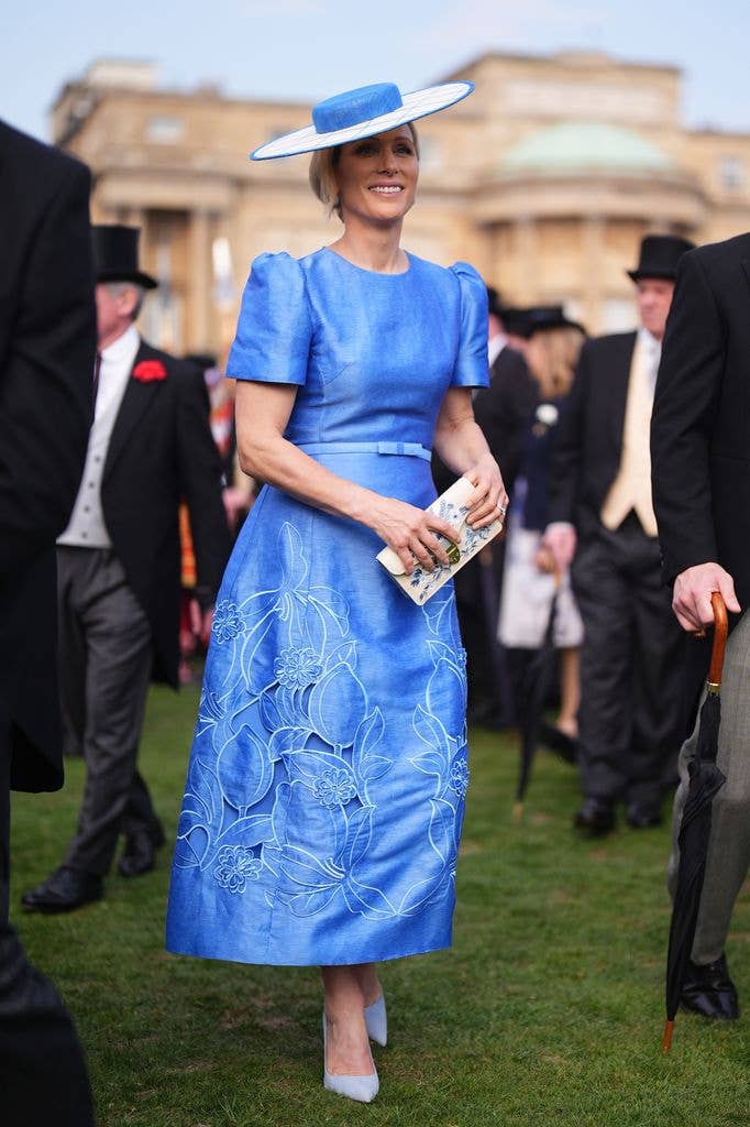 Zara Tindall meets guests during a Royal Garden Party at Buckingham Palace  in blue dress