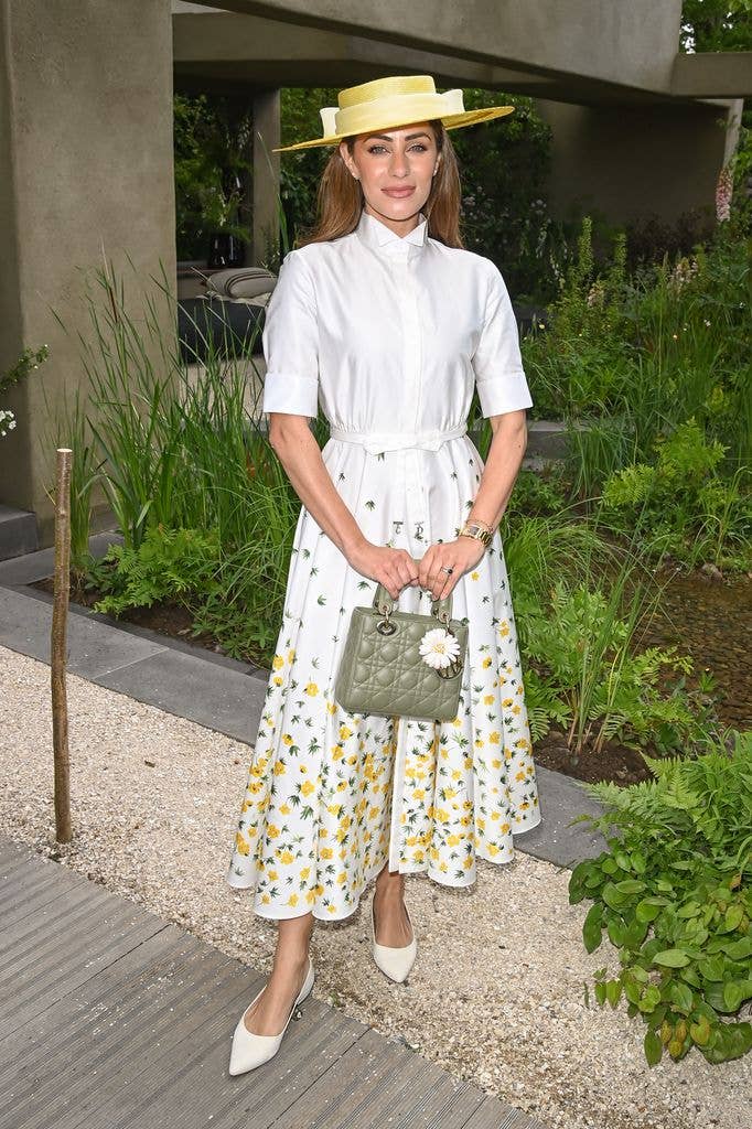 Lydia Millen wears a yellow hat, white shirt and white and yellow midi skirt
