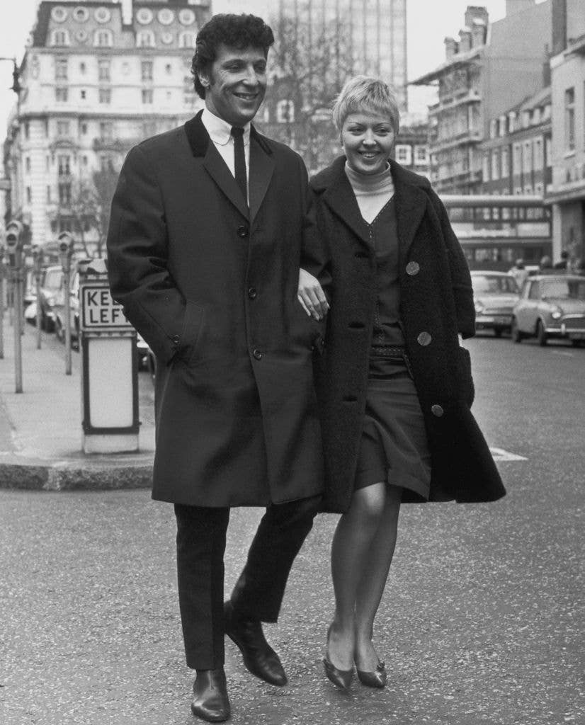 Welsh singer Tom Jones and his wife Linda walking down a street, 1965. 