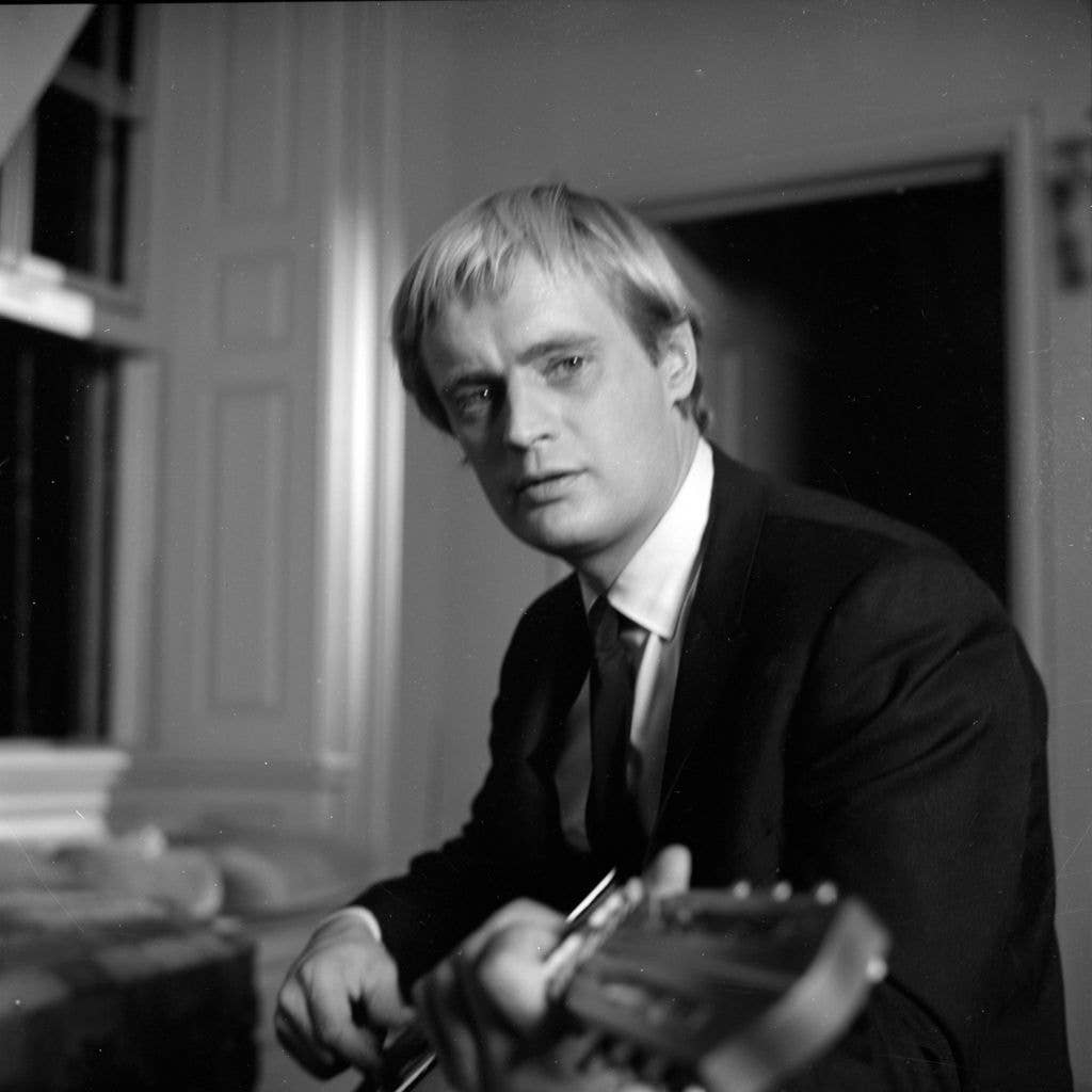 Black and white photo of David McCallum posing with his guitar.