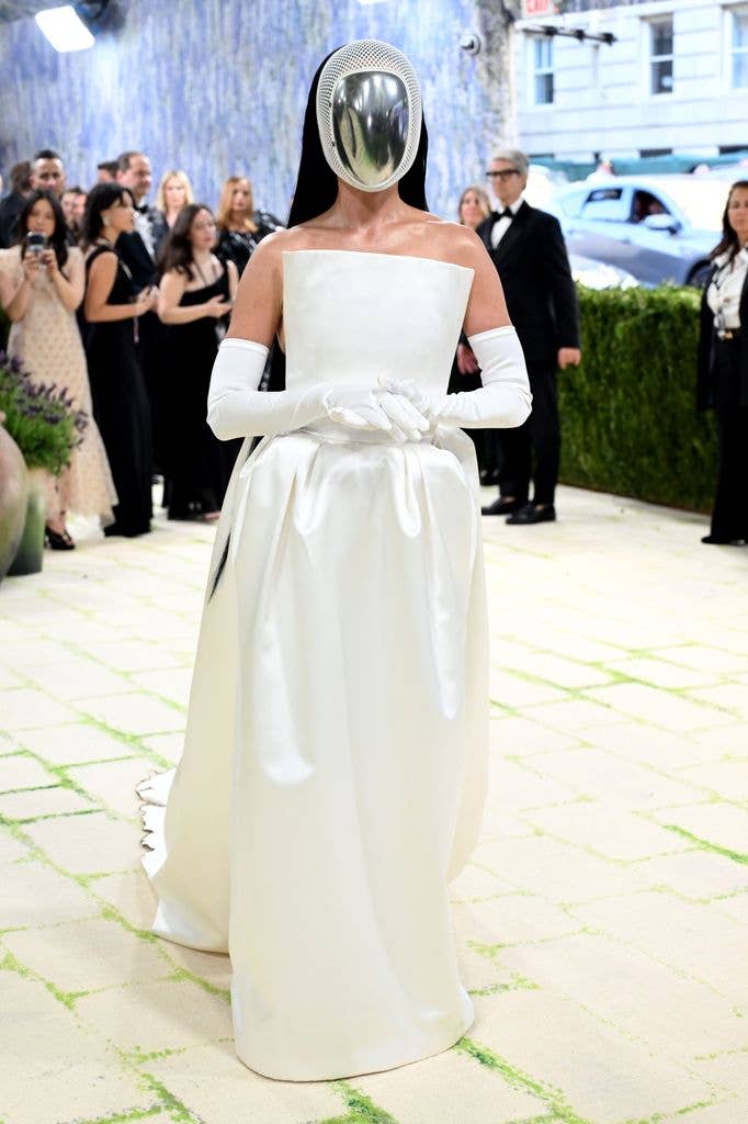 Katy Perry in a white dress and silver futuristic face mask