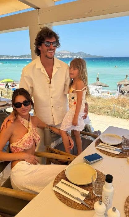 Misse Beqiri and Jake Hall with their daughter at a beachside restaurant