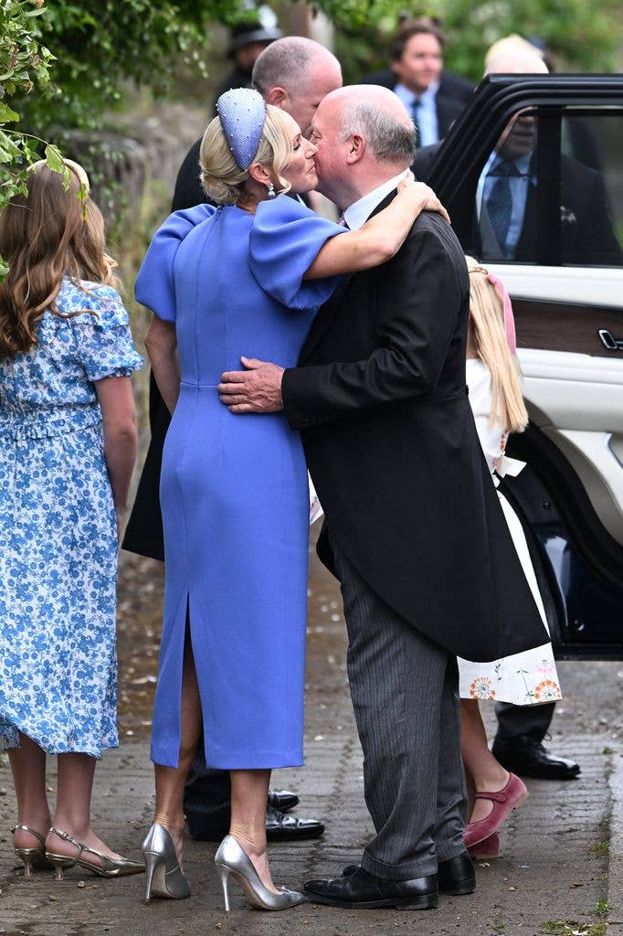 Zara Tindall hugging a family member wearing a blue dress and heels