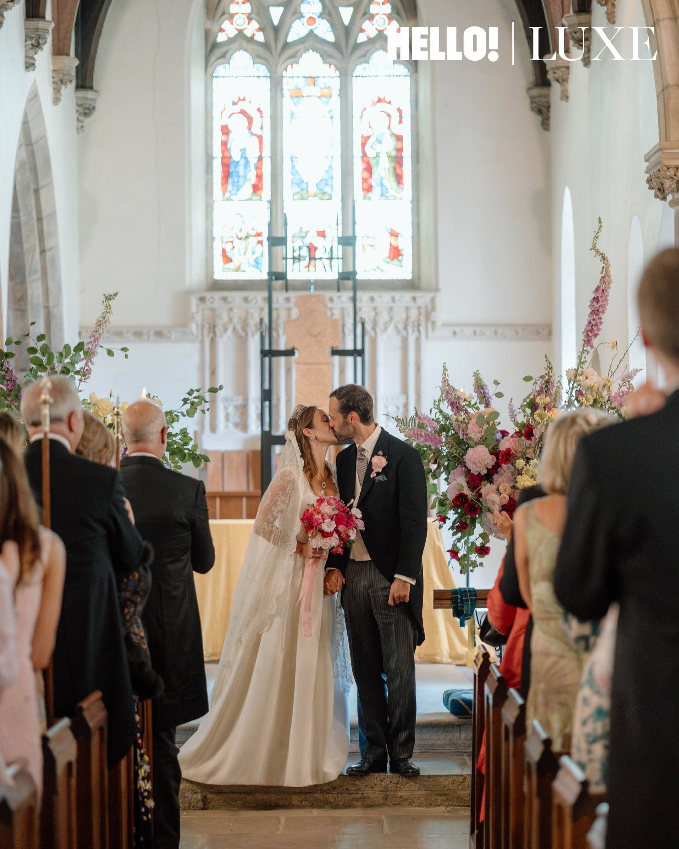 The happy couple kiss in front of their guests
