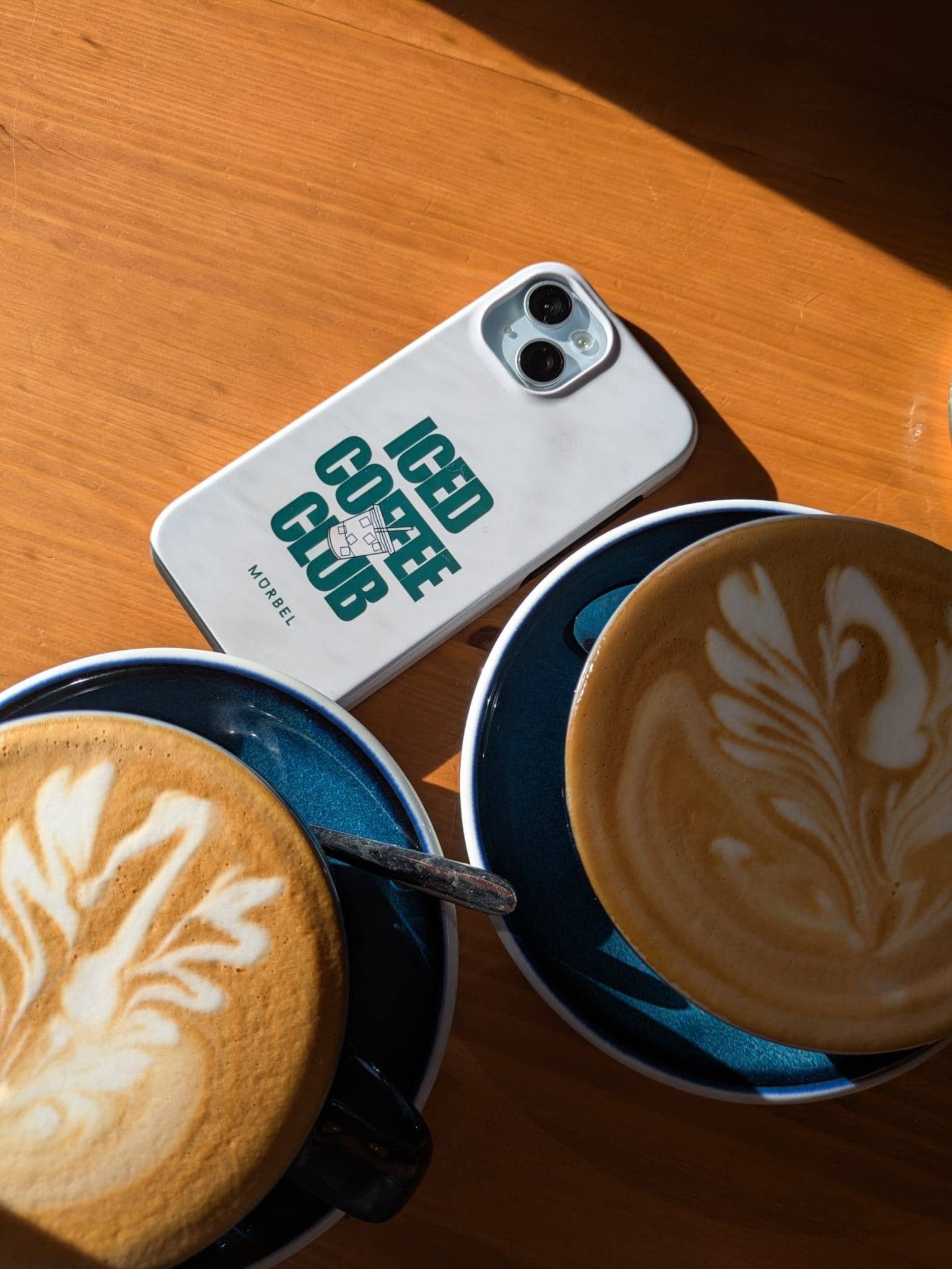 two coffees and a phone in the sun 