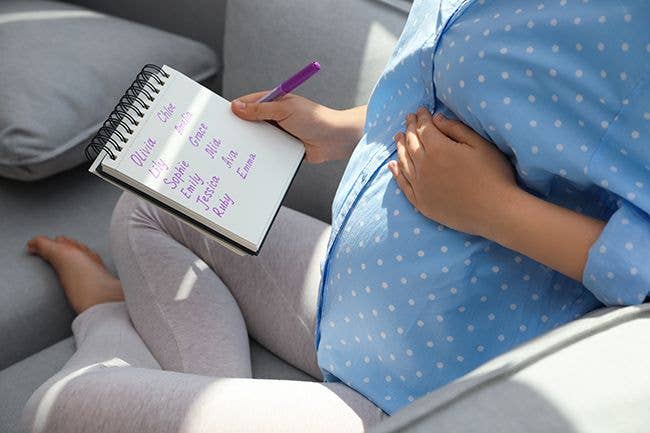 A pregnant woman writing a list of baby names