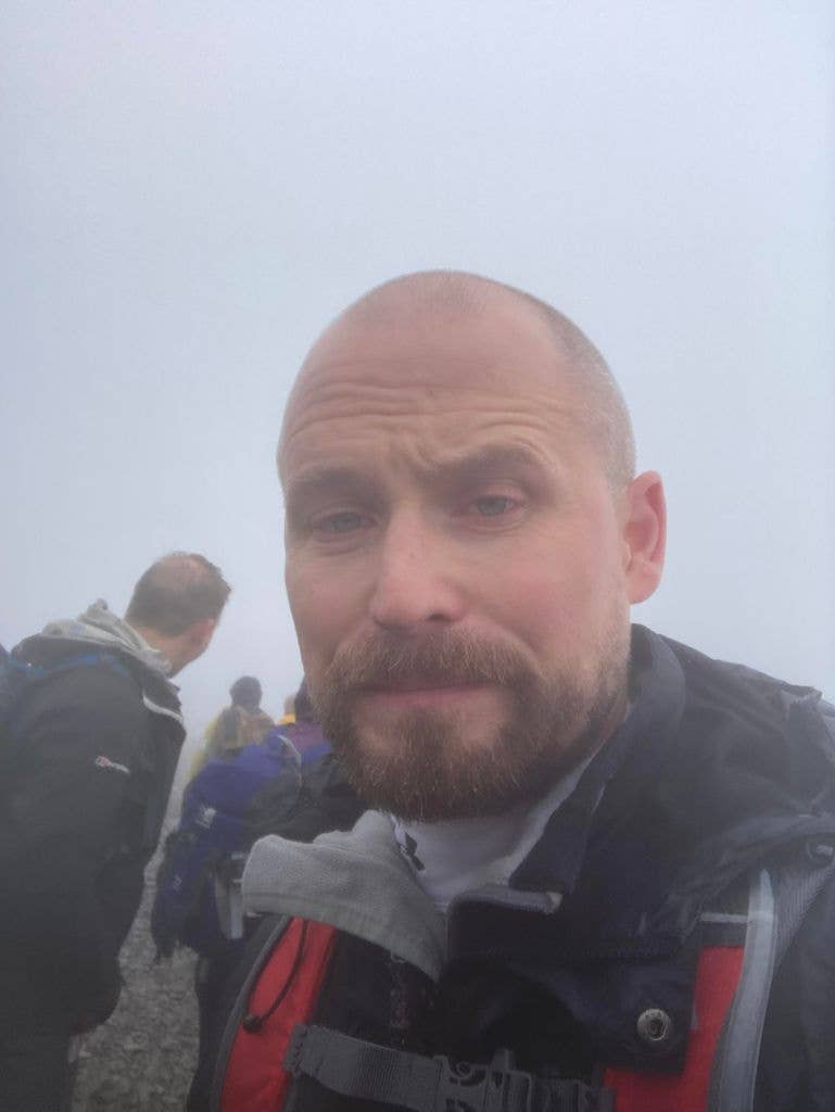 Close of man wit shaved head in the mist looking tired
