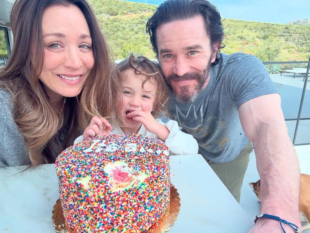 Kaley Cuoco and Tom Pelphrey pose for a photo with a gender reveal cake alongside their daughter Matilda, shared on Instagram