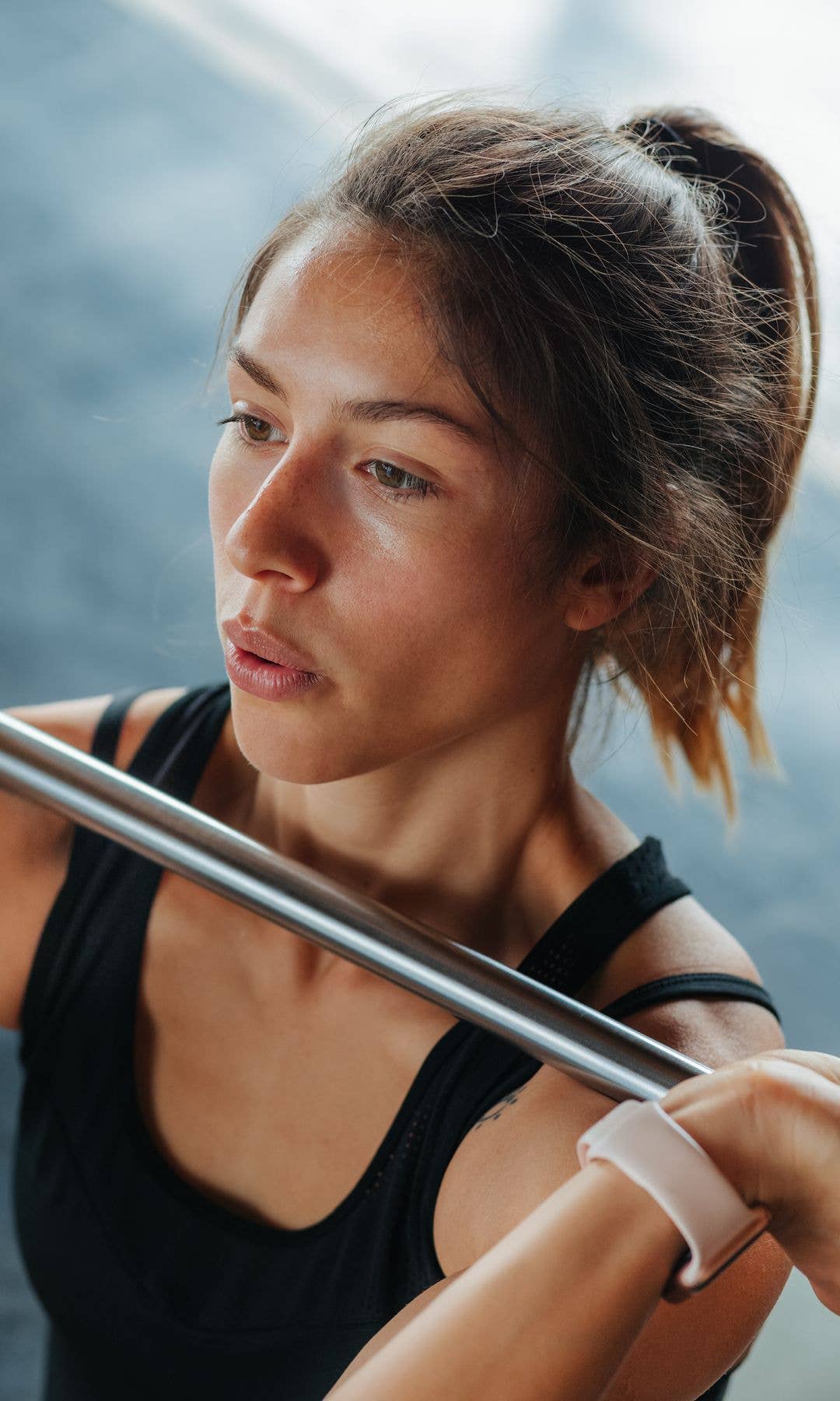 Close up of a model holding a bar bell with glowing skin 