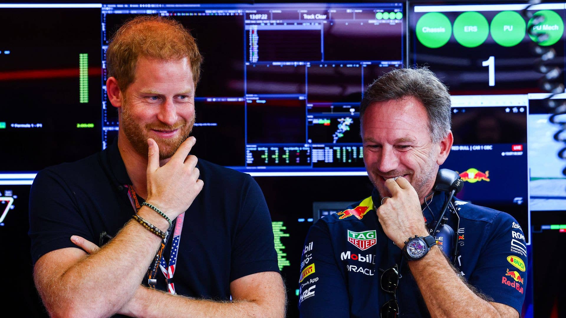 Prince Harry standing with Christian Horner in front of several monitors